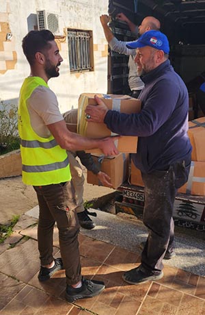 Kamal Mansour receives a food pack in southern Lebanon,