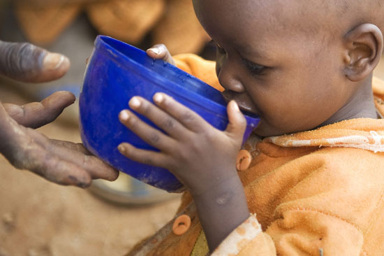 young boy drinking from cup