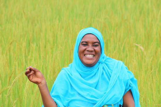 Rice farmer Mariam Abdallah stands in the midst of her thriving rice field near Dodoma, Tanzania. LWR is working with rice farmers to improve their production, income and livelihoods.
