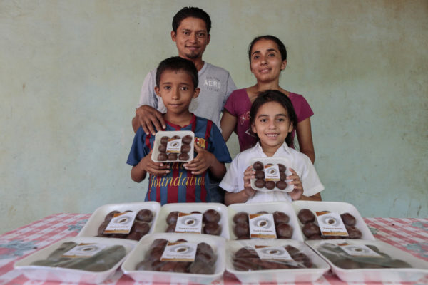 Willaims Savaria and his family pose with cocoa tablets he produces to sell. 