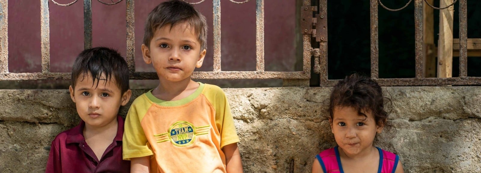 Three children look into the camera.
