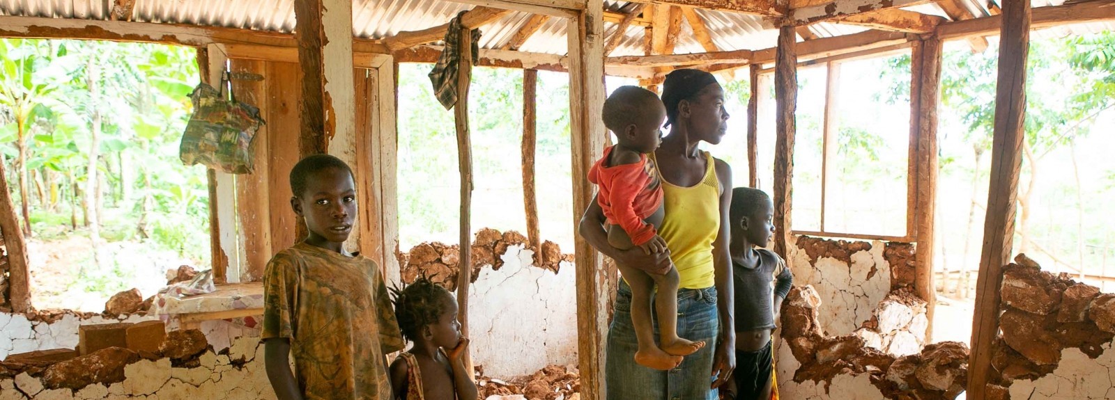 A woman and children stand inside a crumbling structure