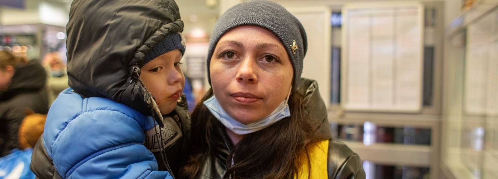 A mother holds her son at a train station in Poland