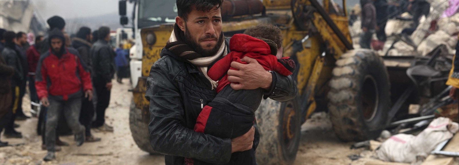 A man carries a child from wreckage after earthquake in Turkey