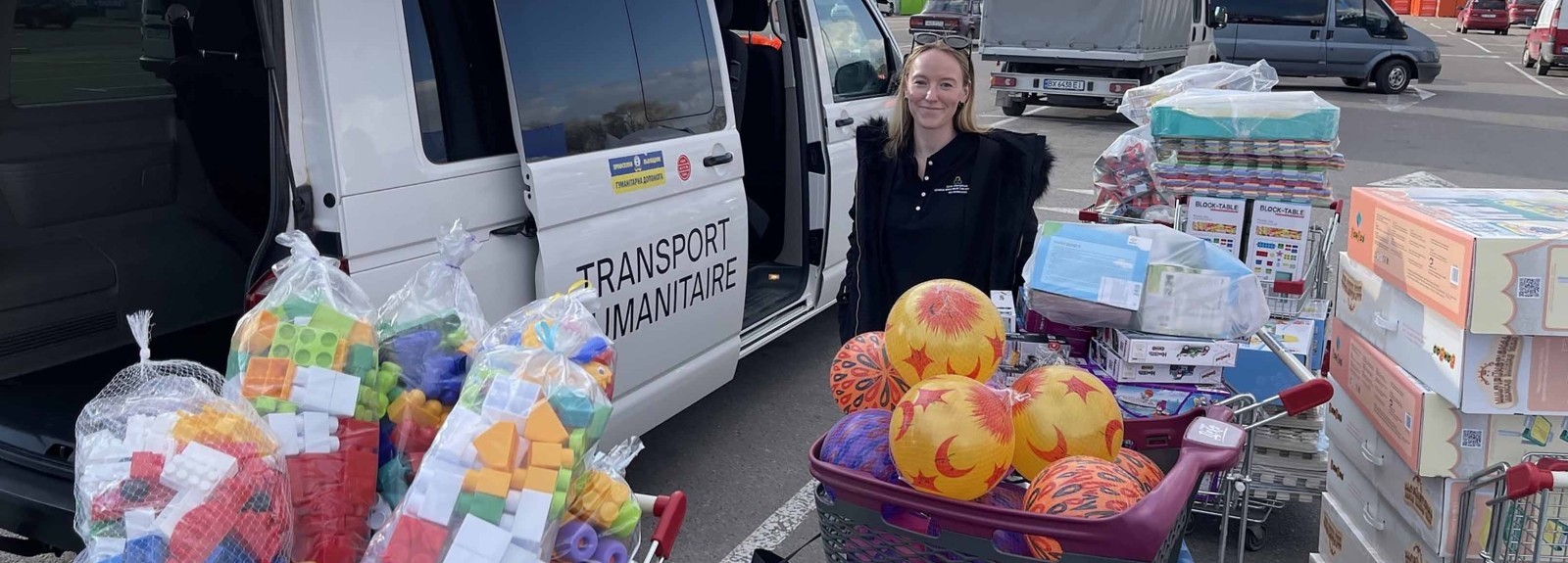 A woman stands amongst toys for Ukrainian refugee children
