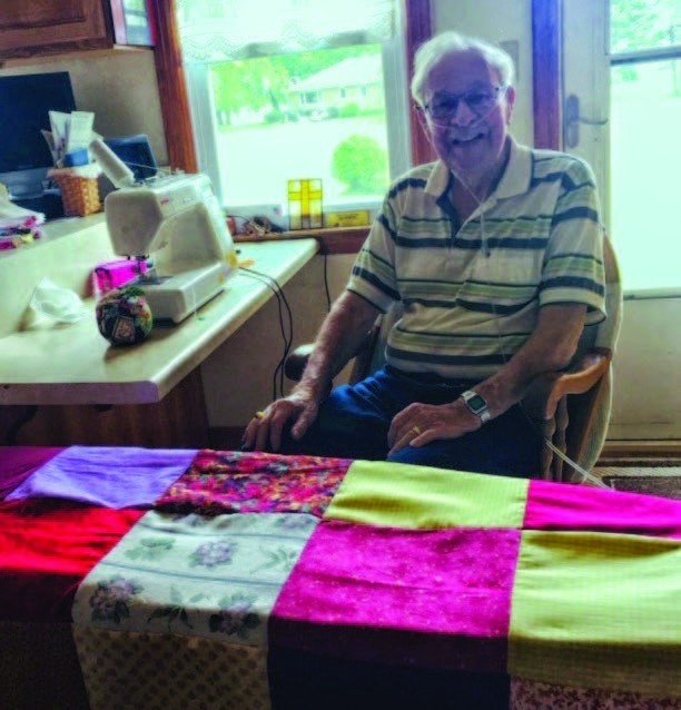 Bob Ashley sits at his sewing machine, where he made quilt tops as part of a 3-member quilting team at Immanuel Lutheran Church in LaSalle County, Ill.