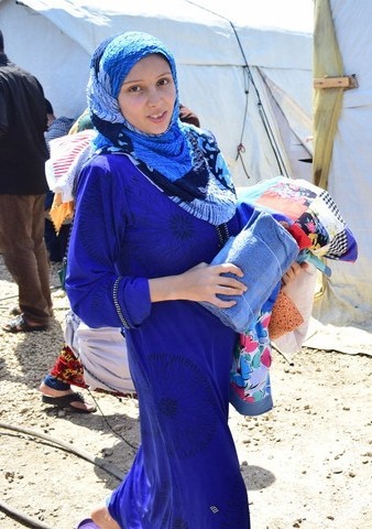 A refugee from Lebanon holding the Gethsemane Quilter's creation.