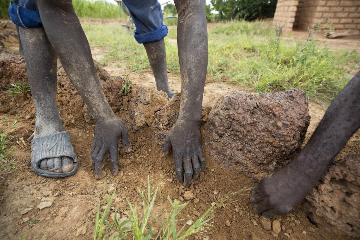 Farmers pitch in together to construct a small stone wall in Gnagna Province, Burkina Faso. (Photo by Jake Lyell for Lutheran World Relief)