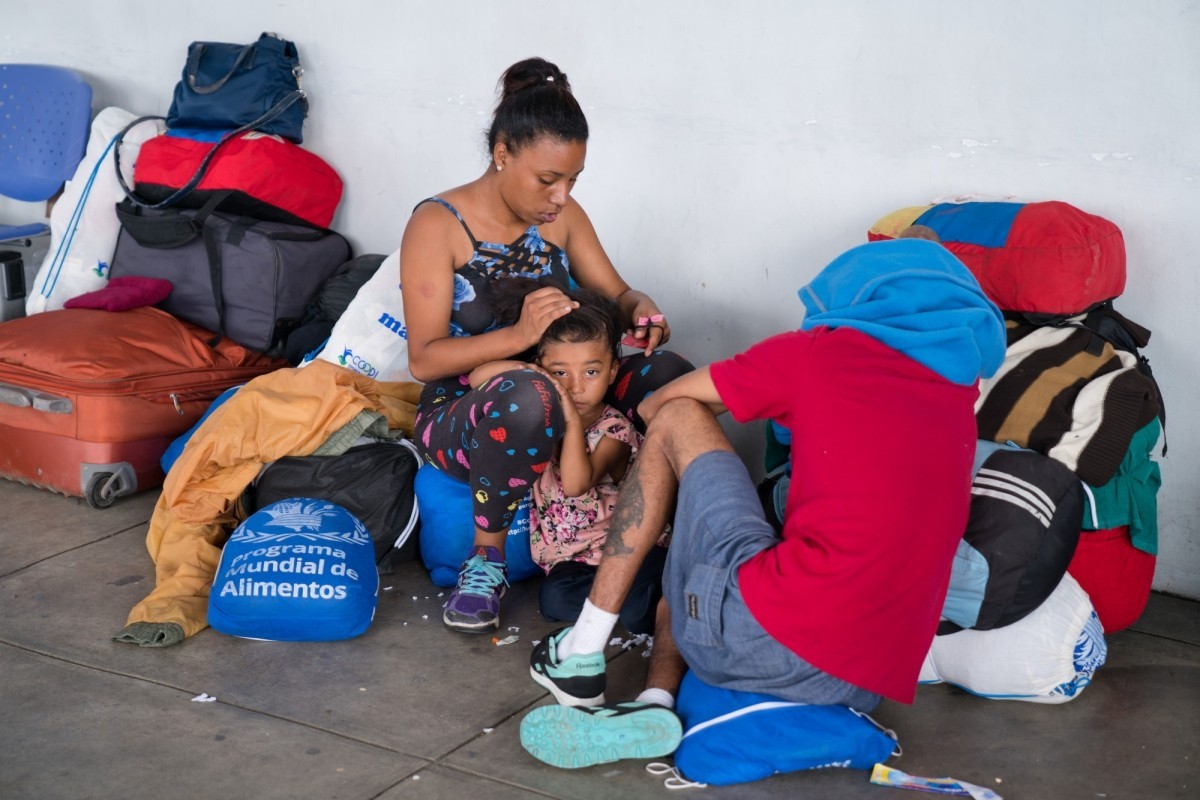 Families applying for refugee status wait at the Peru/Ecuador border crossing in Tumbes, Peru.