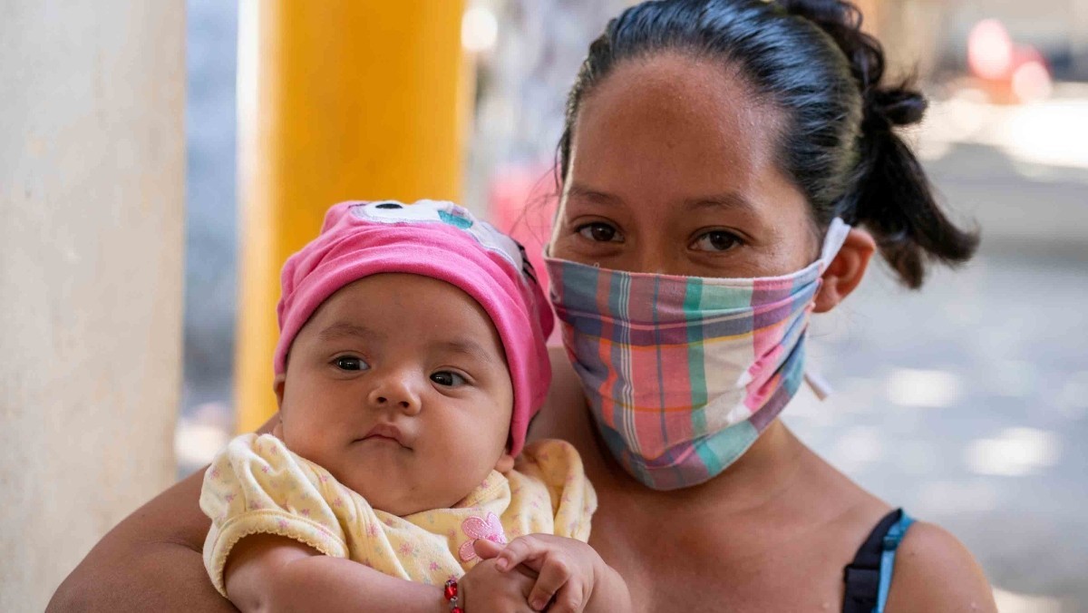 Belkis Reyes with her infant daughter at a COVID prevention kit distribution co-sponsored by ChildFund at a family shelter in Santa Barbara, Honduras.