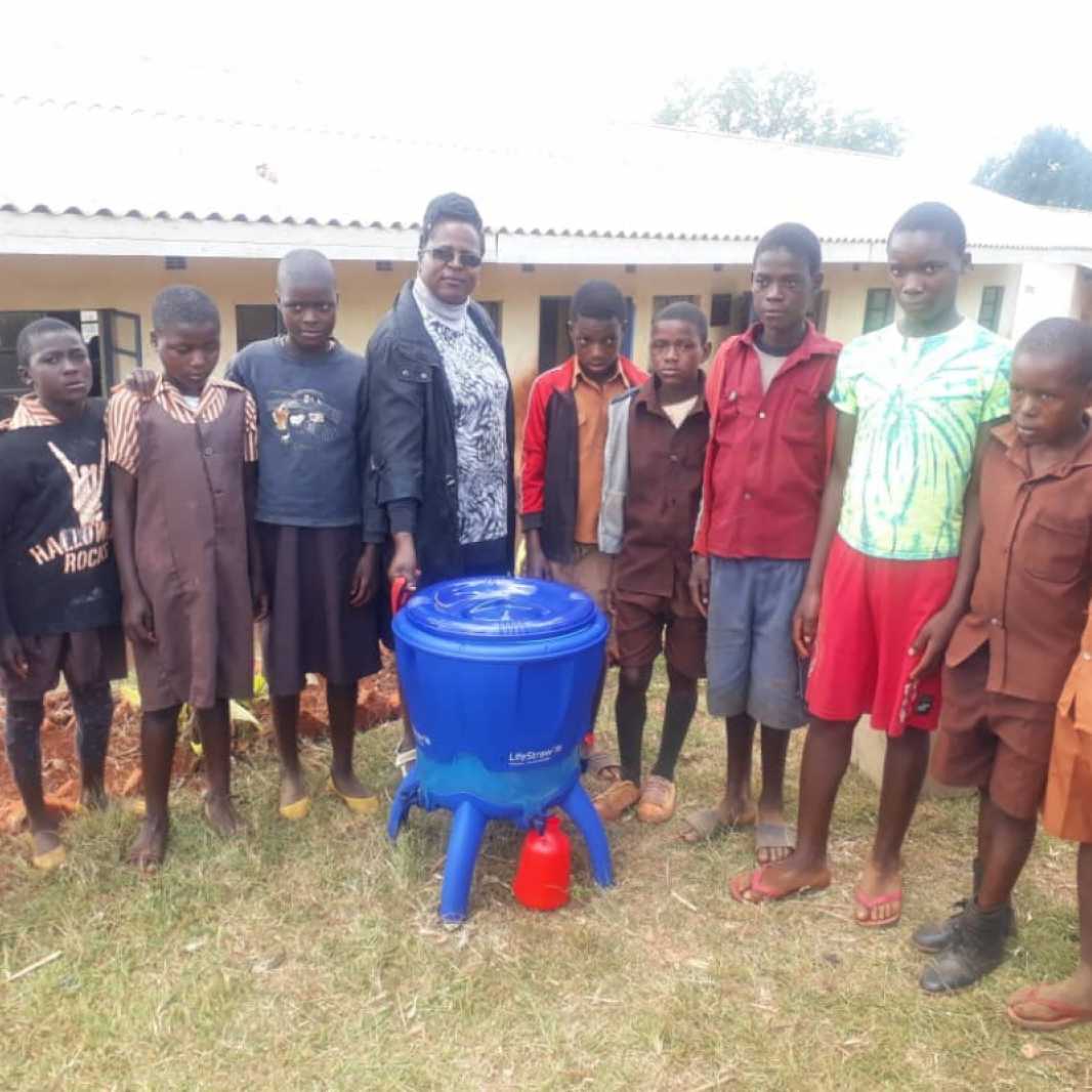 Students and a school staff member display their new water filter, provided to them by you after Cyclone Idai hit their community in March 2019. (Photo courtesy of Smile for Africa)