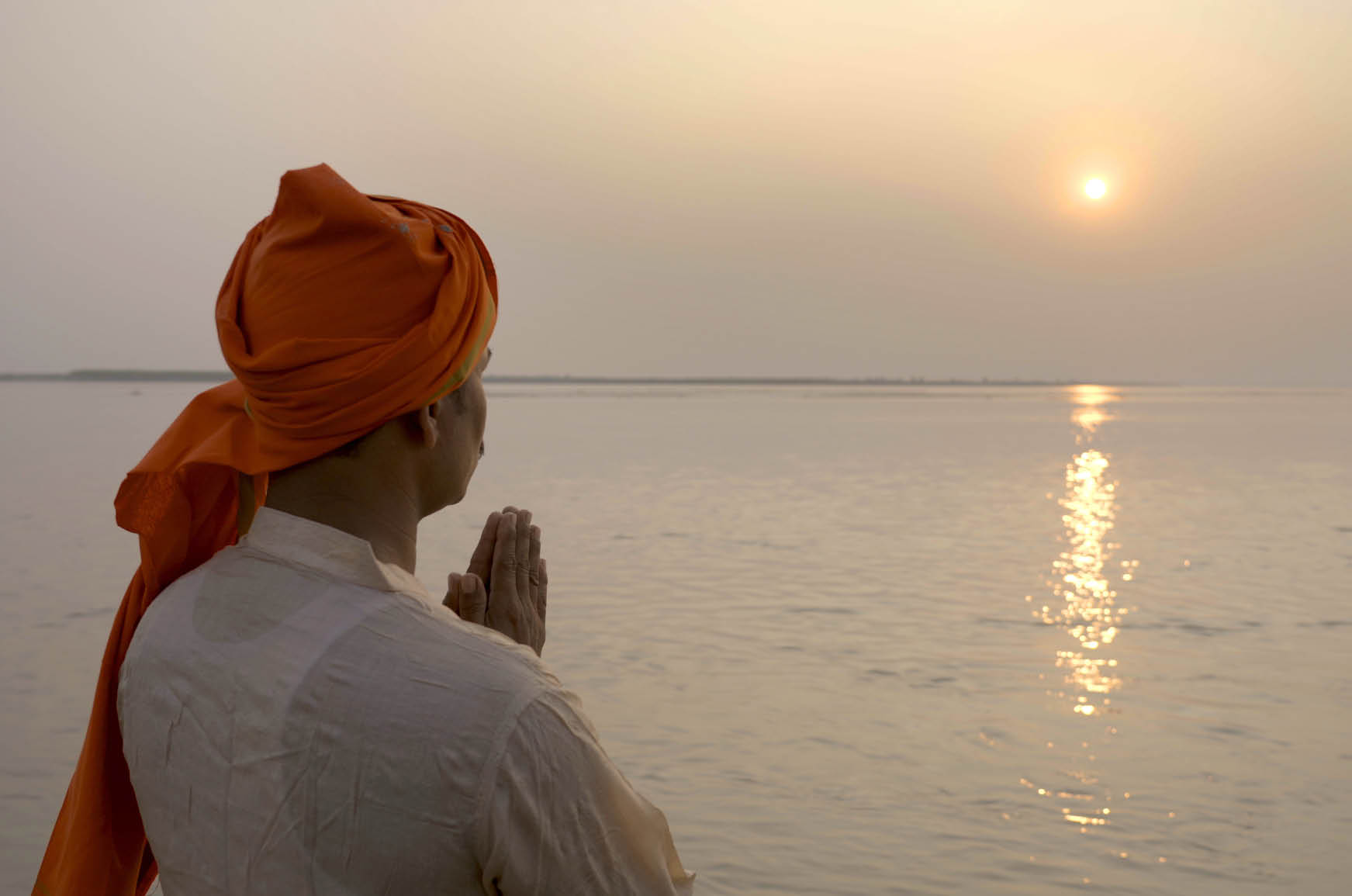 Vijay Singh (38) prays along the Gandak River, which divides the countries of India and Nepal  His family is facing the simultaneous crises of the COVID-19 outbreak along with seasonal flooding, which has become worse and worse with each passing year  West Champaran District, Bihar State - India  November 2020  Jake Lyell & Associates for Lutheran World Relief 