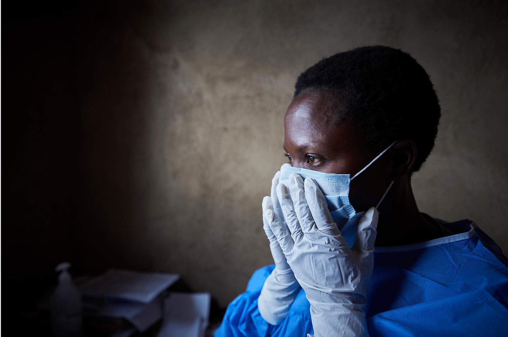 Adele Kavira Saasita puts on protective clothing in a clinic in Beni, a city in eastern Democratic Republic of the Congo that has been hard hit by the Ebola outbreak that began in 2018  She is a nurse in the clinic, which is supported by IMA World Health and the Programme de Promotion de Soins SantÈ Primaires 